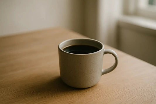 Americano in a ceramic mug on a pale oak counter with soft natural light in a minimalist Scandinavian kitchen